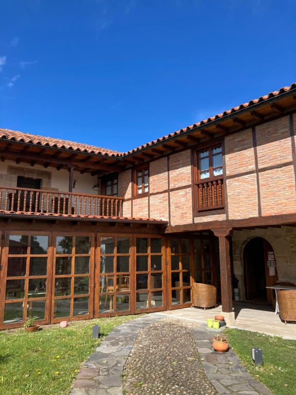 un gran edificio con puertas y ventanas de madera en Posada La Casona de Los Güelitos, en Santillana del Mar