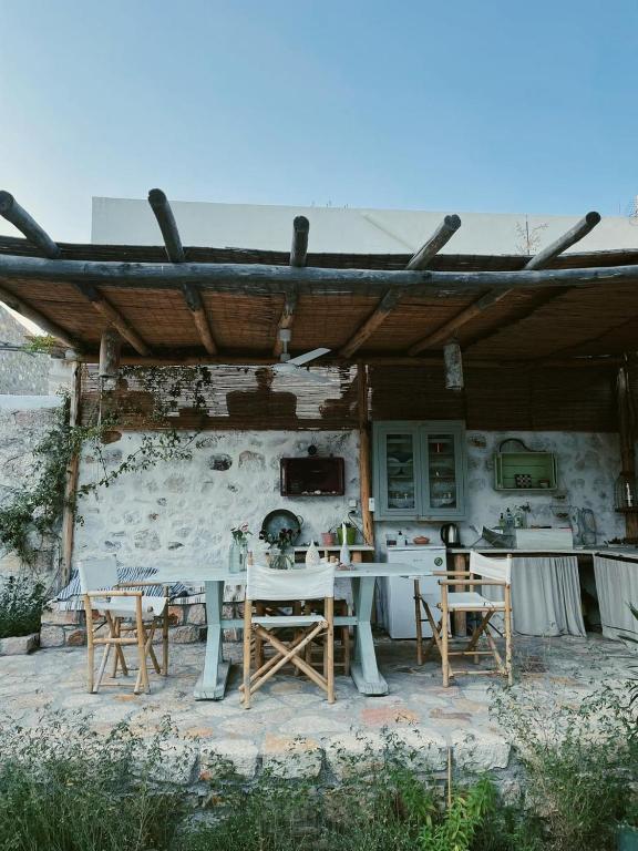 a table and chairs under a wooden roof at Latmos 1860 in Skala