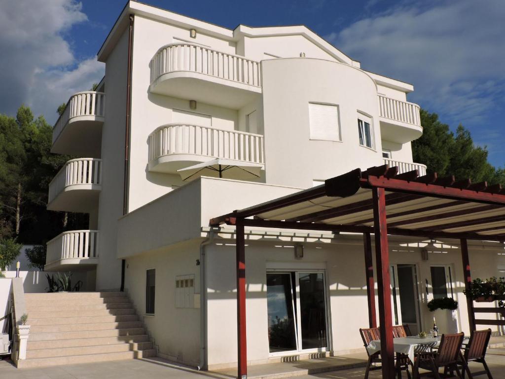 un edificio blanco con mesa y sillas en Villa Bianca, en Trogir
