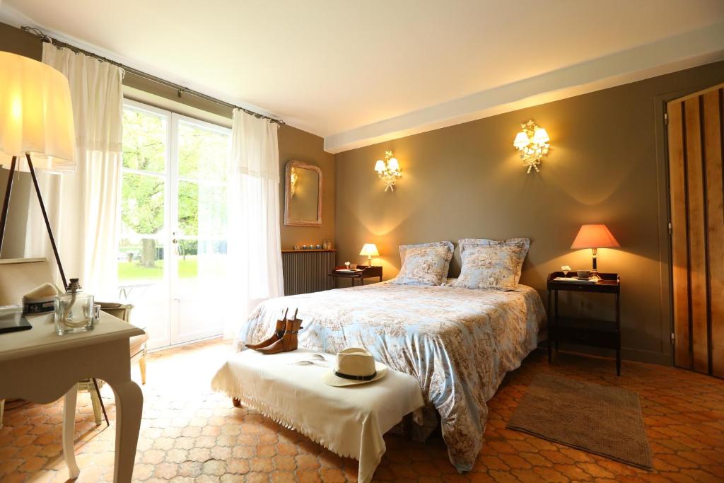 a bedroom with a bed and a table and a window at Le Clos de Bénédicte in Bondues