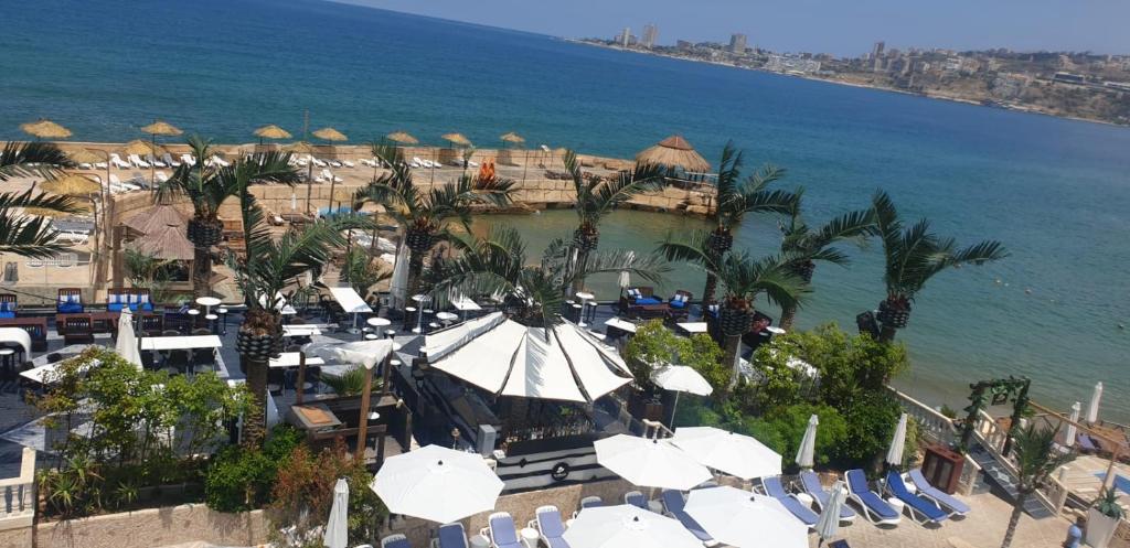 uma vista aérea de uma praia com cadeiras e guarda-sóis em Lamedina Hotel & Resort em Jounieh