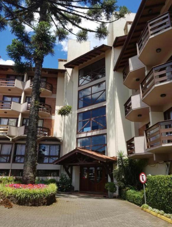 a large building with a tree in front of it at Pousada do Serrano - Rua Torta in Gramado