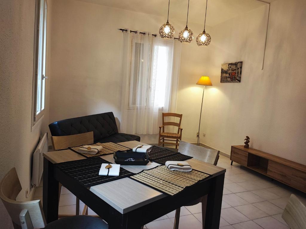 un salon avec une table et un canapé dans l'établissement le jardin botanique, à Perpignan