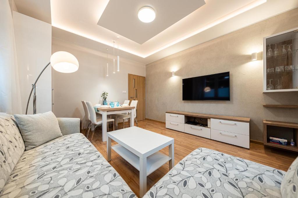 a living room with a couch and a table at Apartment BlueBird Katowice near Spodek MCK & City Center in Katowice
