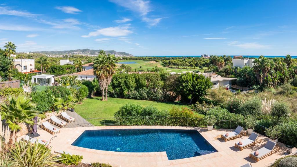 een luchtzicht op een zwembad in een tuin met stoelen bij Villa Miramar by Glasir in Sitges