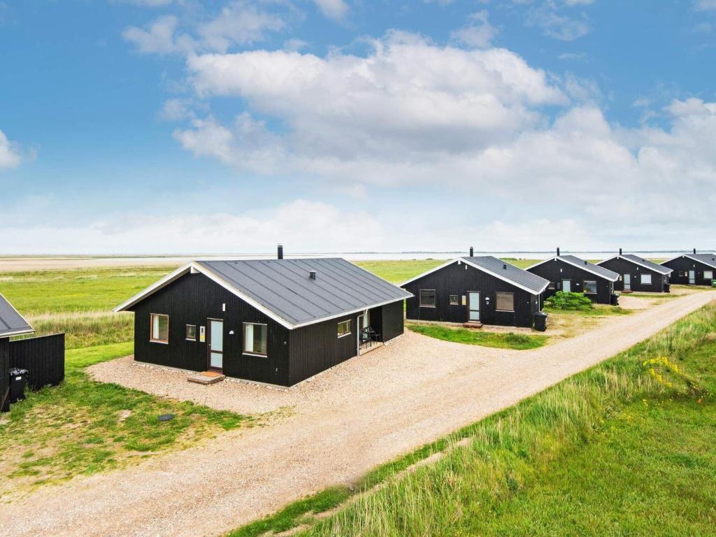 a row of black cabins in a field of grass at 8 person holiday home in Ulfborg in Thorsminde