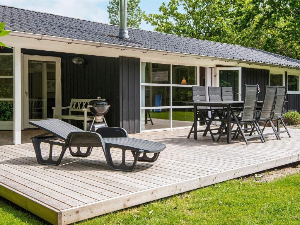 a wooden deck with a table and chairs on it at 6 person holiday home in Hemmet in Hemmet