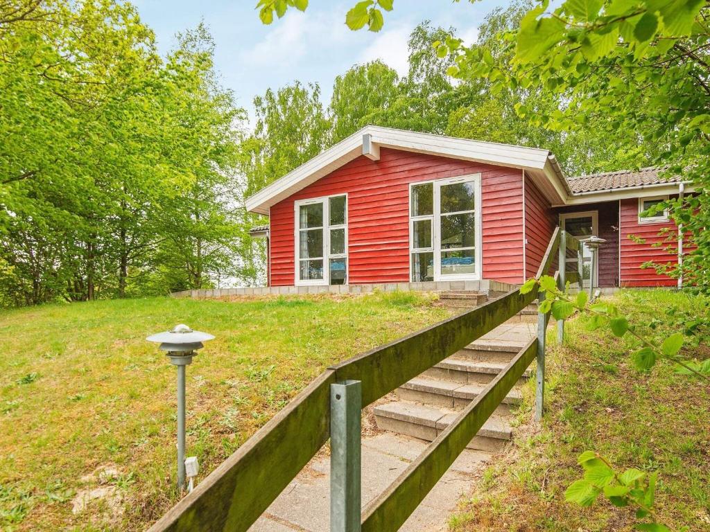 een rood huis met een trap daarheen bij 8 person holiday home in B rkop in Børkop