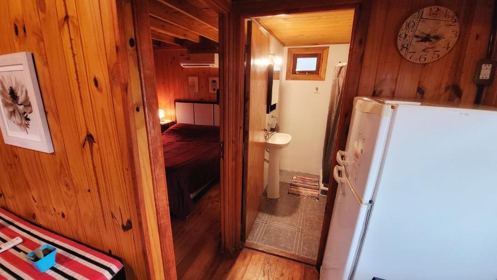 Habitación pequeña con nevera y 1 dormitorio. en Cabañas Pulmahue en Colón
