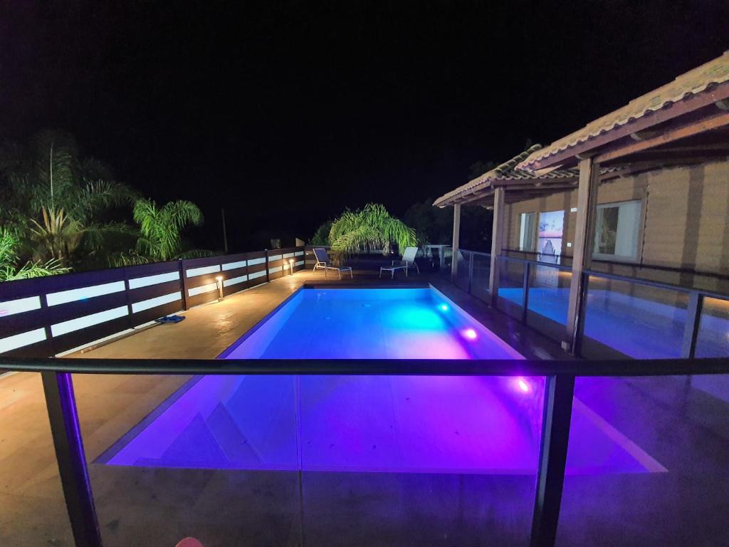 a swimming pool at night with purple lights at Green mountains - הרים ירוקים in Dishon