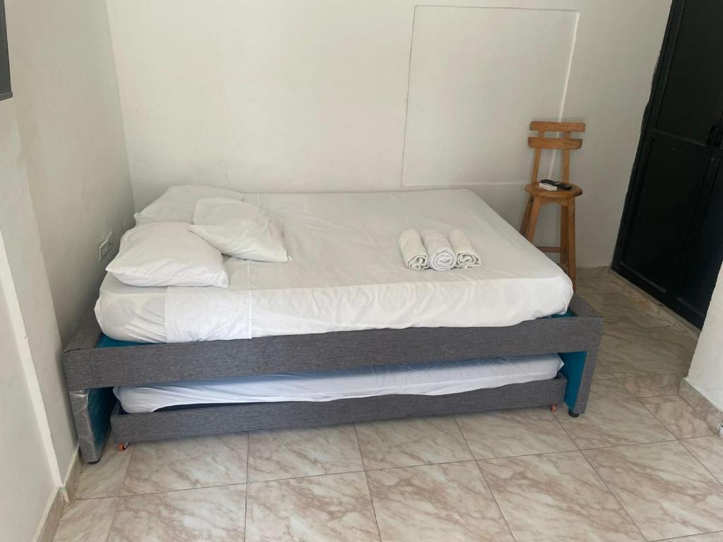 Una cama con dos zapatillas encima. en Sophia House en Cartagena de Indias