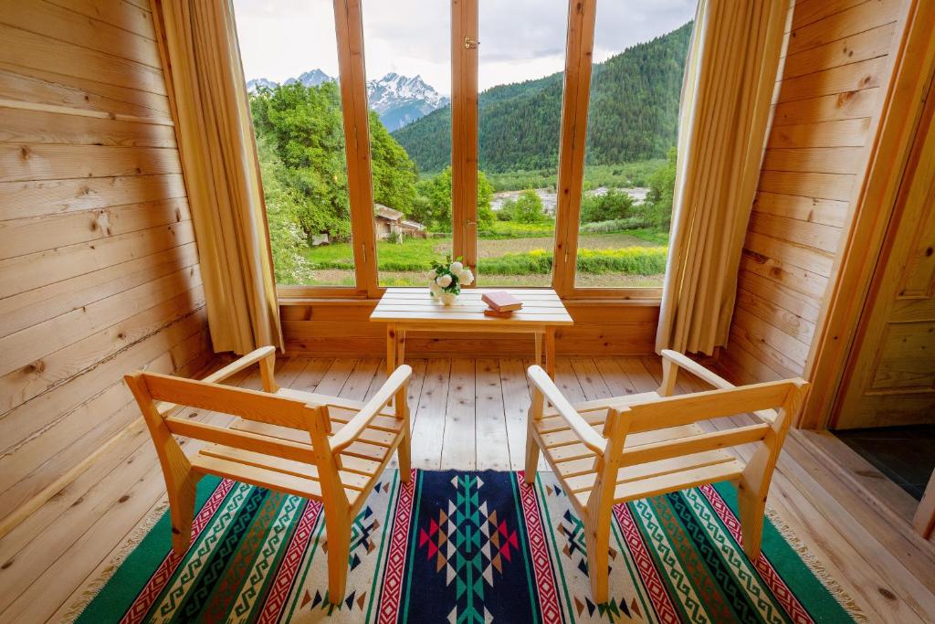 Zimmer mit 2 Stühlen und einem Tisch vor einem Fenster in der Unterkunft Chiora Inn in Chiora