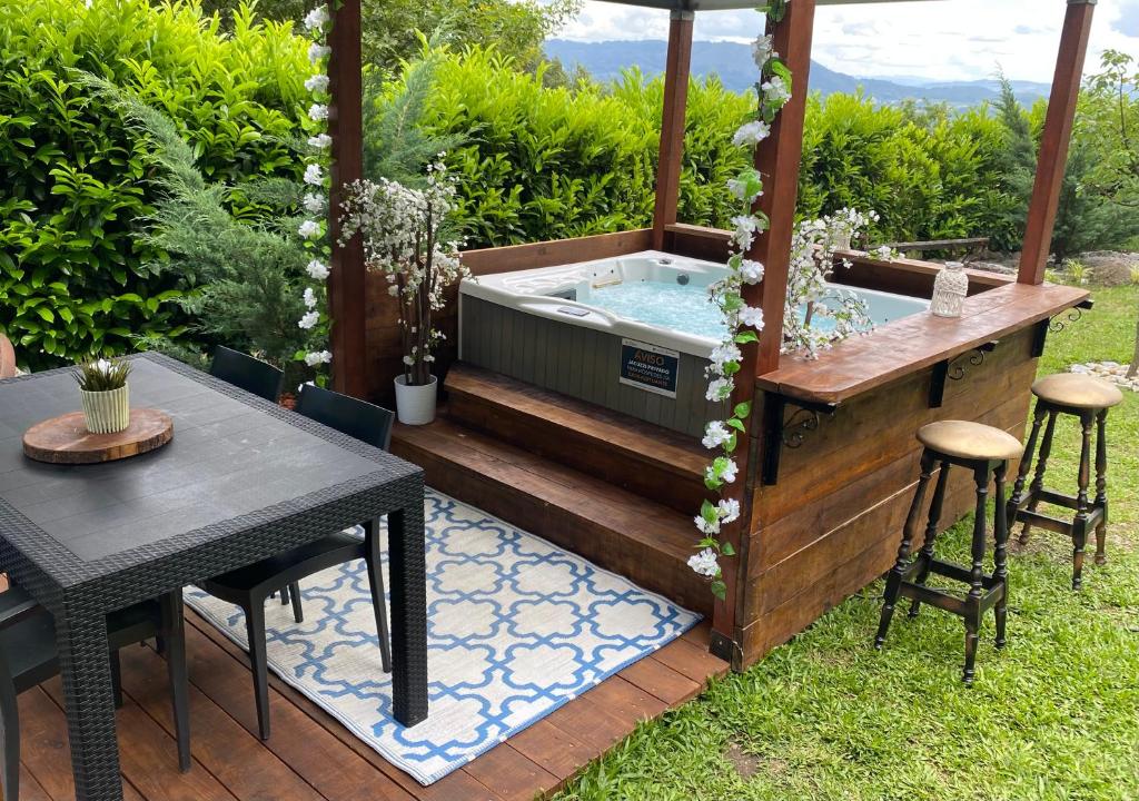 a hot tub in a garden with a table at Quinta Leiras de Mondim in Pico