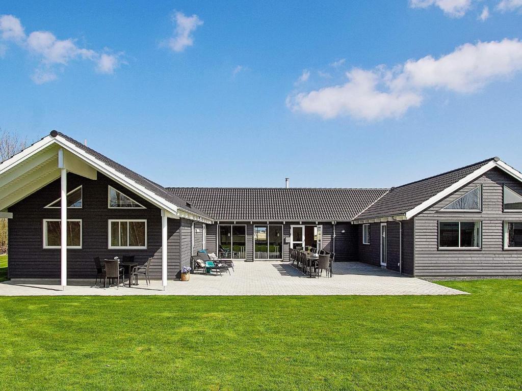 a black house with a patio and grass at Holiday home Kappeln XXIV in Kappeln