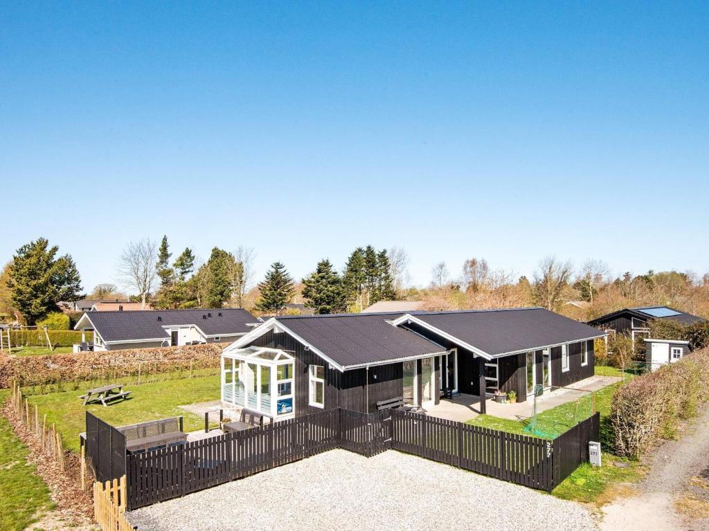 a house with a black fence in front of it at 9 person holiday home in Juelsminde in Sønderby