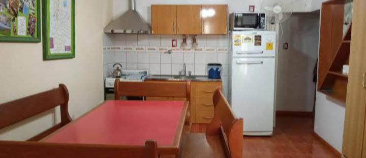 a kitchen with a red table and a white refrigerator at Aldea Granpas in Embalse