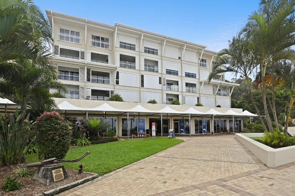 Deep Blue Apartment 1 Tangalooma في تنجالوما: مبنى ابيض كبير وامامه ساحة فناء