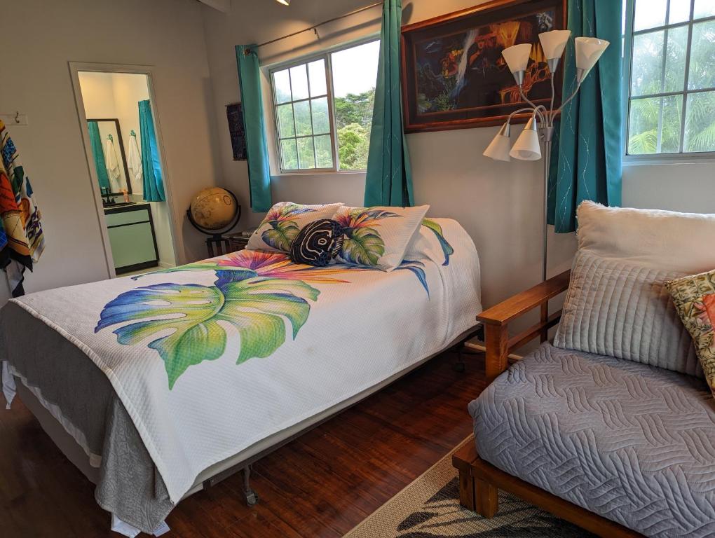 a bedroom with a bed and a chair at Hilo Luxury Suite in Hilo