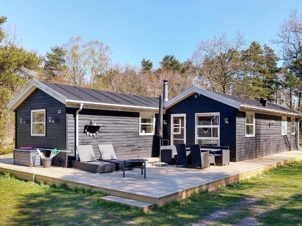 een blauw huis met een terras ervoor bij Holiday Home Skovbrynet II in Odde