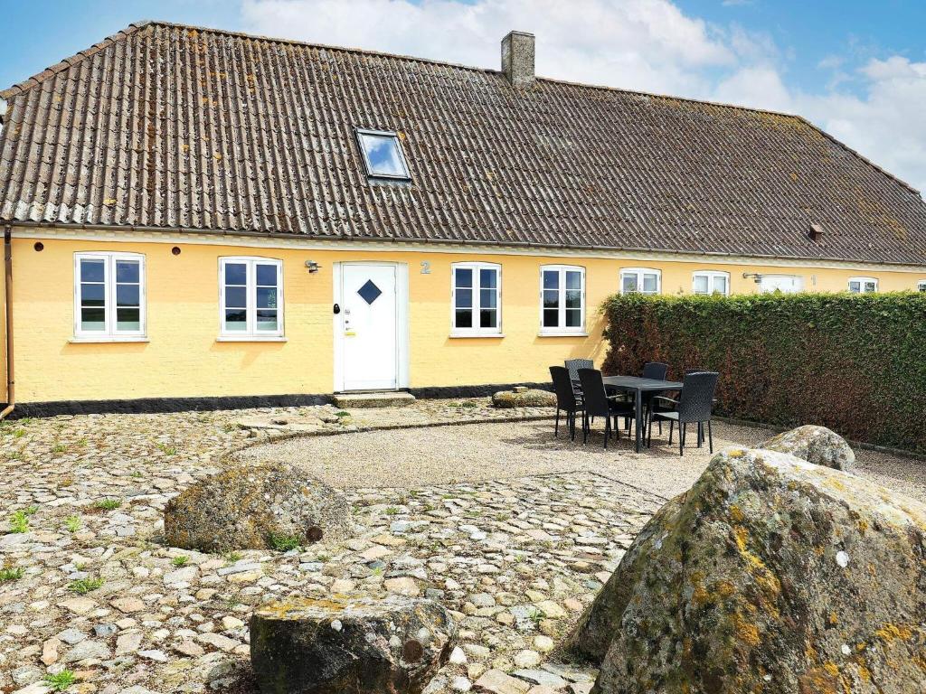 a yellow house with a table and chairs in front of it at Apartment Faaborg II in Fåborg