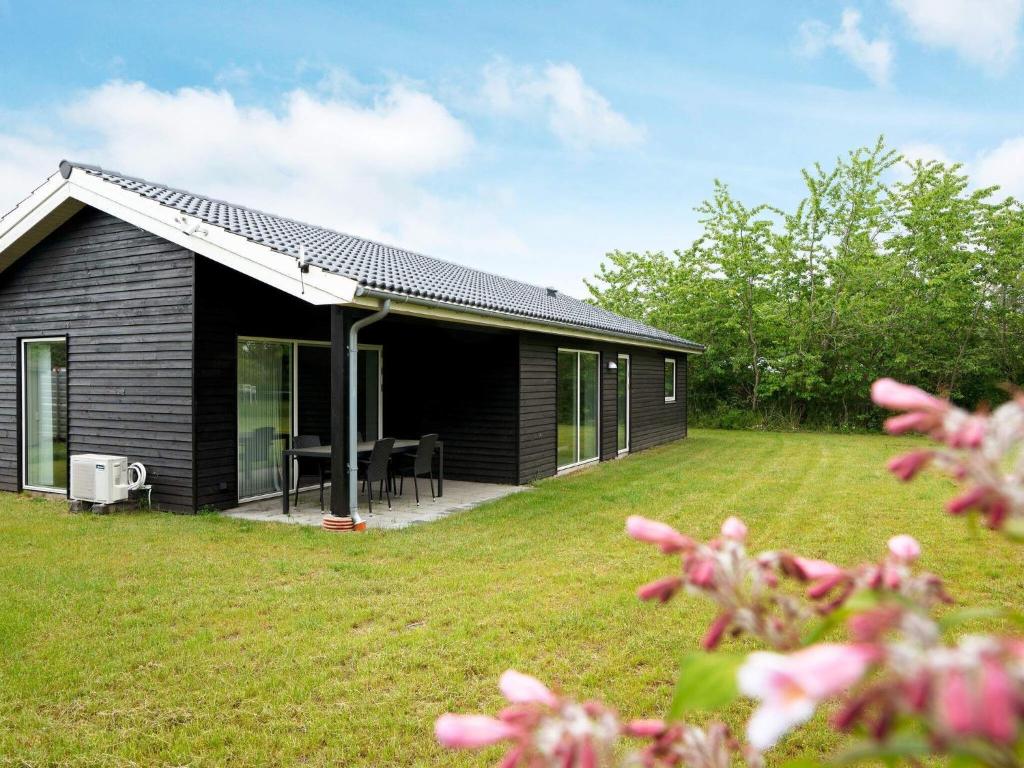una casa negra con césped delante en 6 person holiday home in Eskebjerg, en Eskebjerg