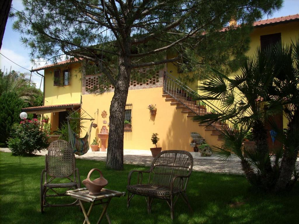 two chairs and a table in the yard of a house at B&B Piceno in Castel di Lama