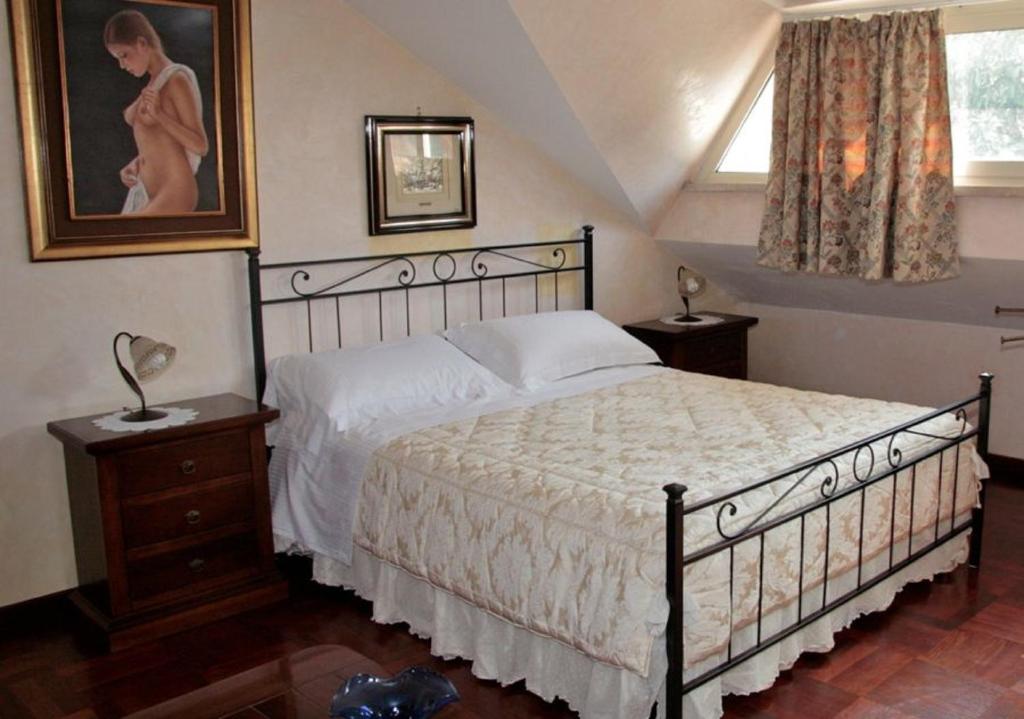 sypialnia z łóżkiem i zdjęciem kobiety w obiekcie B&B Domus Gratiae w mieście Ostia