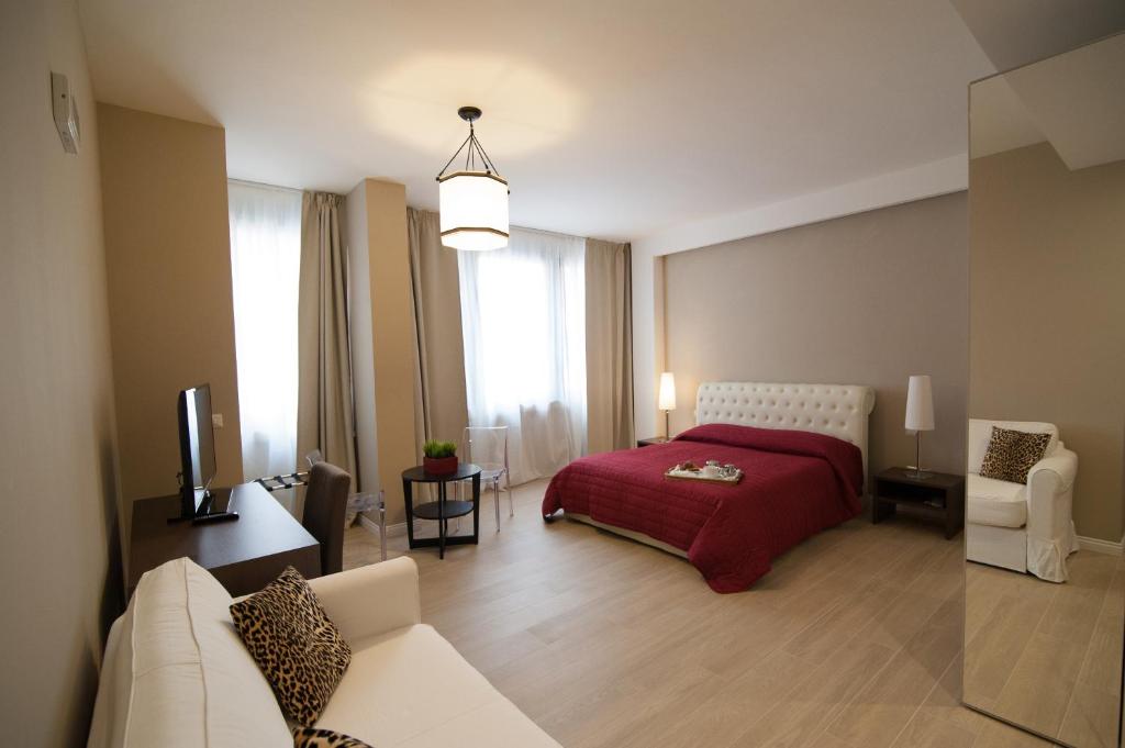 a bedroom with a bed and a couch and a tv at Les Suites Bari Italian Excellence Bed and Breakfast in Bari
