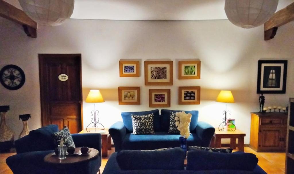 Villa Sueño Azul B&B في غواناخواتو: غرفة معيشة مع أريكة زرقاء وطاولة