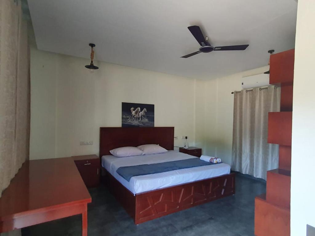 a bedroom with a bed and a ceiling fan at LUNAPIENA RESORTS in Tiruvankod