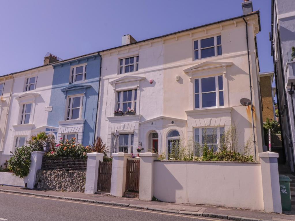 a white and blue house on a street at 6 Gloster Terrace in Folkestone