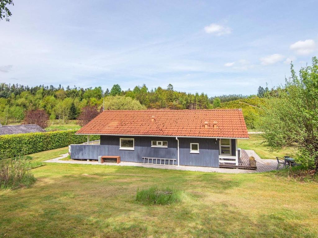 a blue house with an orange roof in a yard at Holiday home Silkeborg XIX in Silkeborg