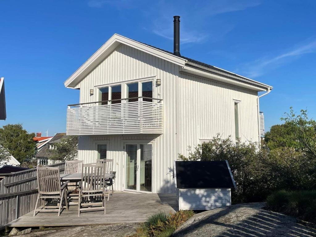 Casa blanca con mesa y sillas en una terraza en Holiday home Hisings-Karra en Röd