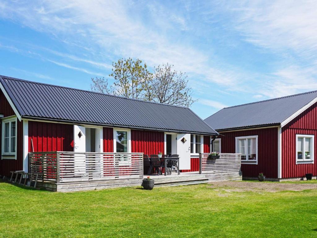 zwei rote und weiße Scheunen mit einem Rasenplatz in der Unterkunft Holiday home STRÖMSTAD XXVIII in Strömstad