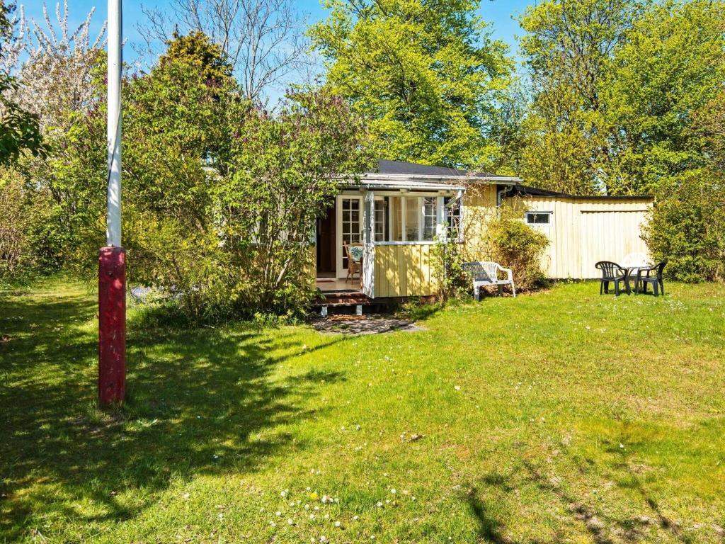 a small cabin in a yard with a table and chairs at Holiday home Odder XXVI in Odder