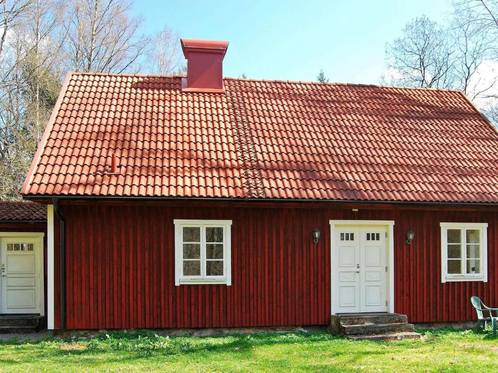 una casa roja con puertas blancas y techo rojo en Holiday home VANKIVA en Vankiva