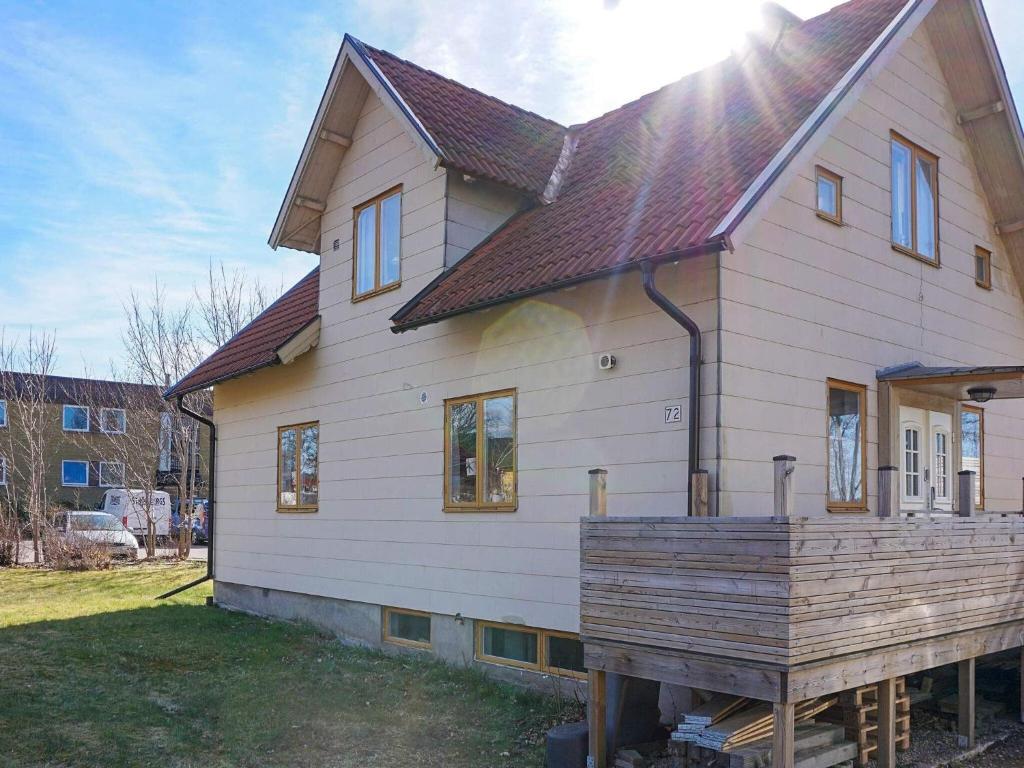 une maison avec une terrasse en bois devant elle dans l'établissement Holiday home HOVMANTORP II, à Hovmantorp