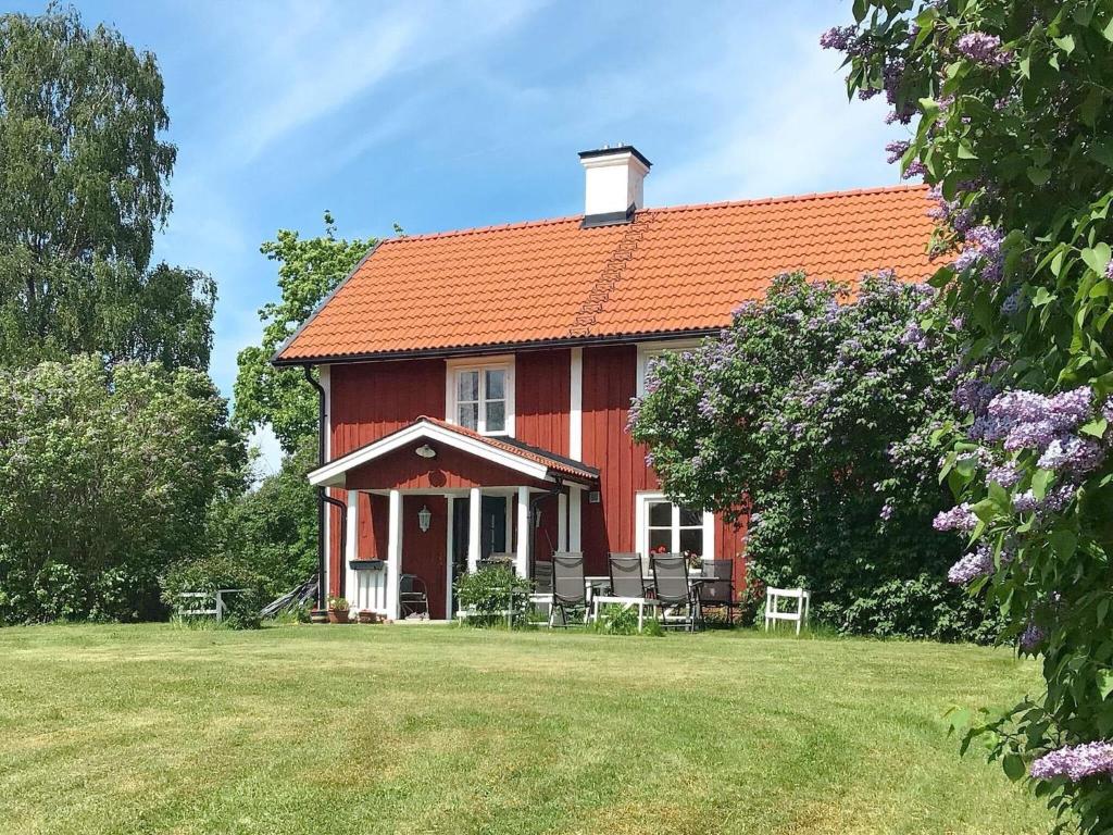 ein rotes Haus mit einem orangenen Dach auf einem Feld in der Unterkunft Holiday home ARBOGA II in Arboga