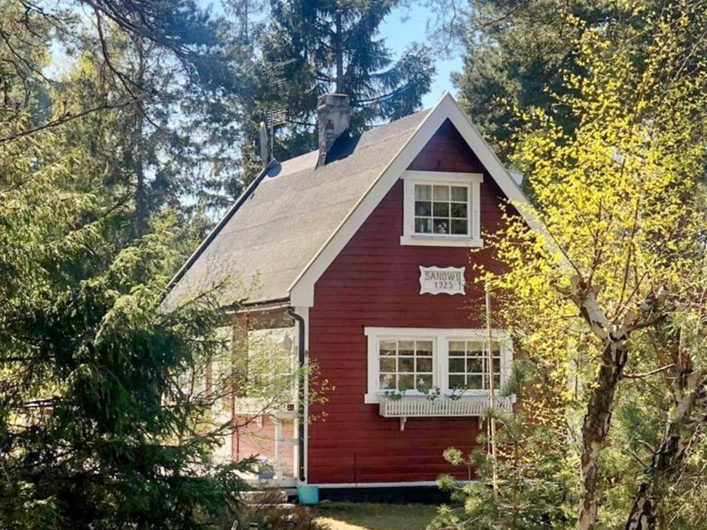 uma casa vermelha com uma janela branca e árvores em Holiday home HÖLLVIKEN III em Höllviken