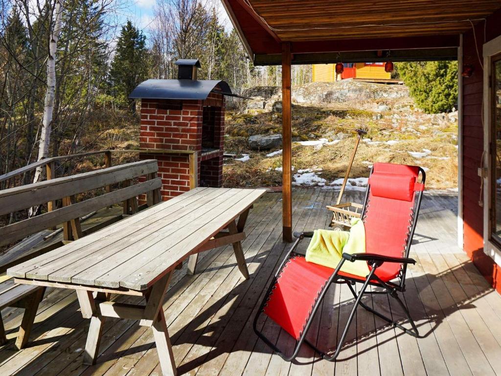 a wooden picnic table and two chairs on a deck at Holiday home NORRTÄLJE X in Norrtälje