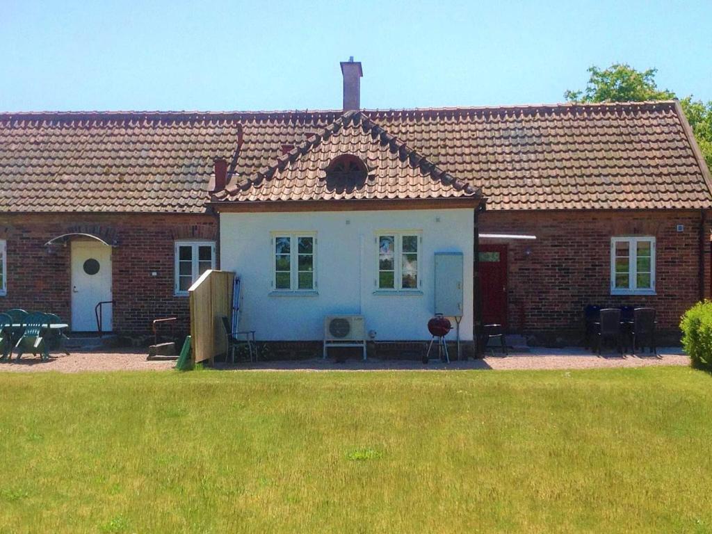 ein weißes Haus mit einem braunen Dach und einem Hof in der Unterkunft Holiday home YNGSJÖ, SVERIGE II in Yngsjö