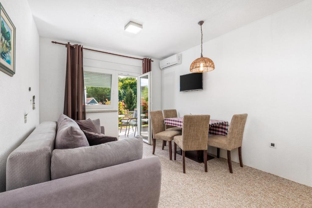 a living room with a couch and a table and chairs at Selak Apartments in Grabovac