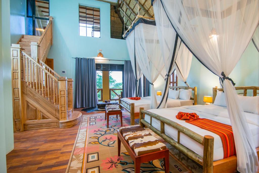 a bedroom with a canopy bed and a staircase at Buffalo Safari Lodge in Katunguru