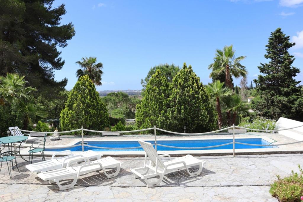 una piscina con tumbonas y una piscina en Villa Quintinha, en Mexilhoeira Grande