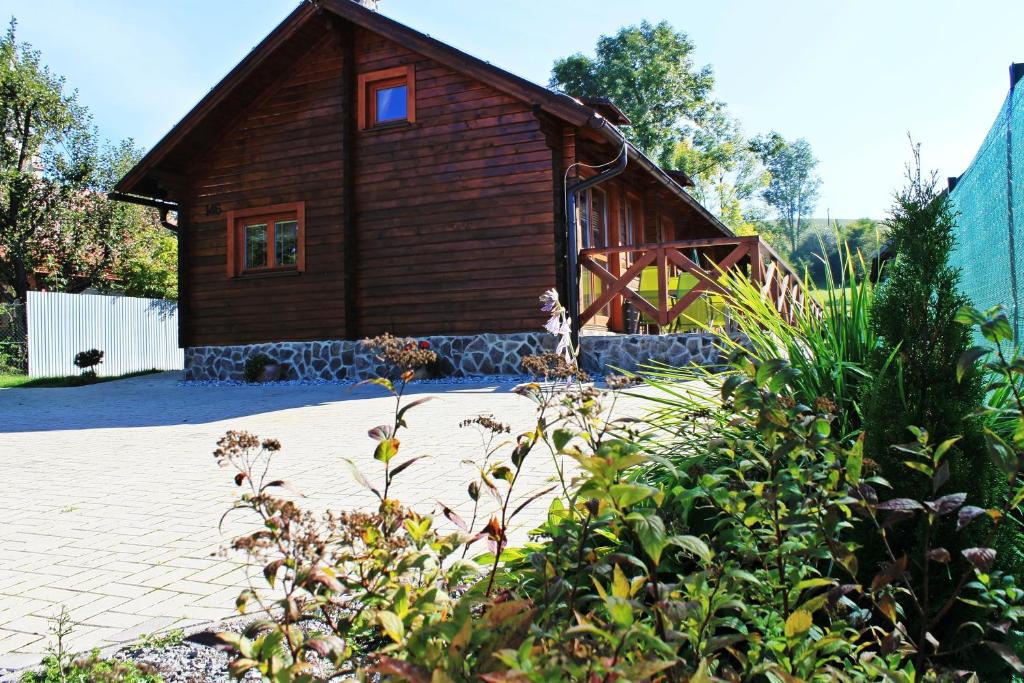 una pequeña casa de madera con un patio de ladrillo en la parte delantera en Drevenica Trnovec en Liptovský Trnovec