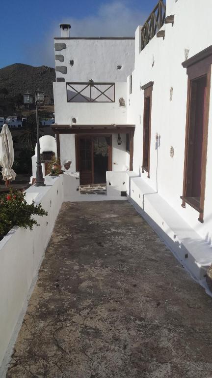 a white building with a courtyard with a driveway at Villa Rural Gloria´s in Haría