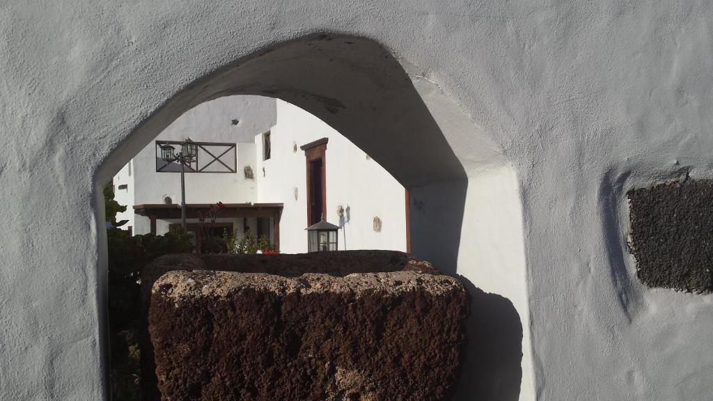 an archway in a building with a house in the background at Villa Rural Gloria´s in Haría