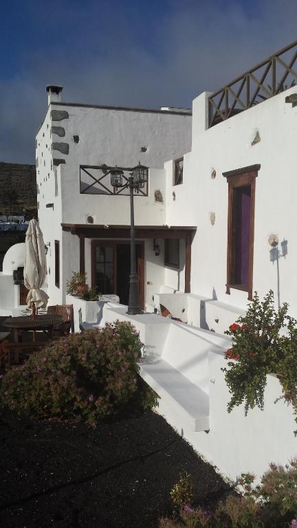 a white building with a table and chairs in front of it at Villa Rural Gloria´s in Haría
