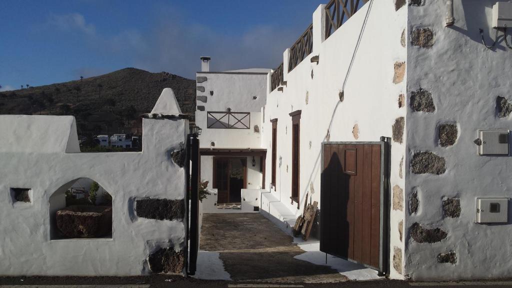 an alleyway between two white buildings with a gate at Villa Rural Gloria´s in Haría