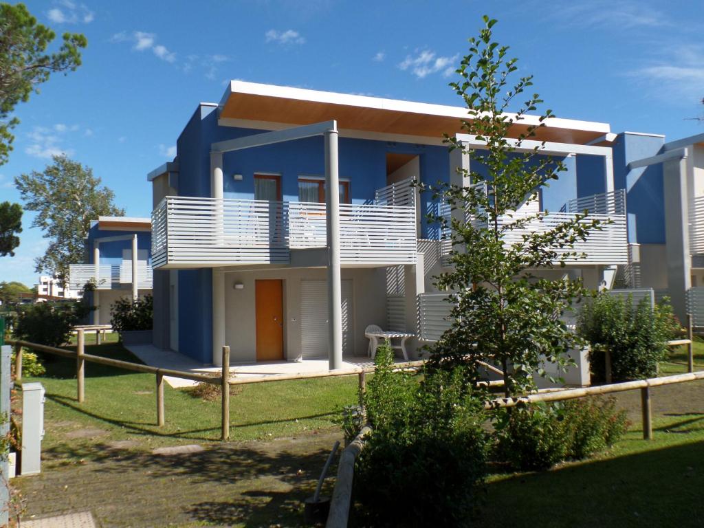 una casa con una fachada azul y blanca en Bibione Mastervillage, en Bibione